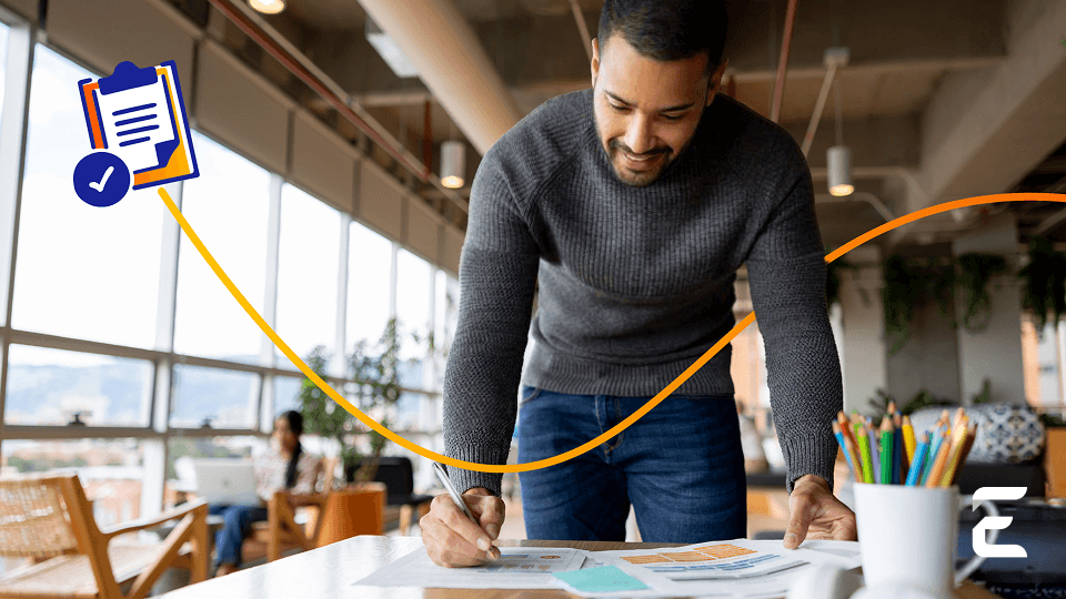 a man is writing on a piece of paper in front of a clipboard with a check mark on it
