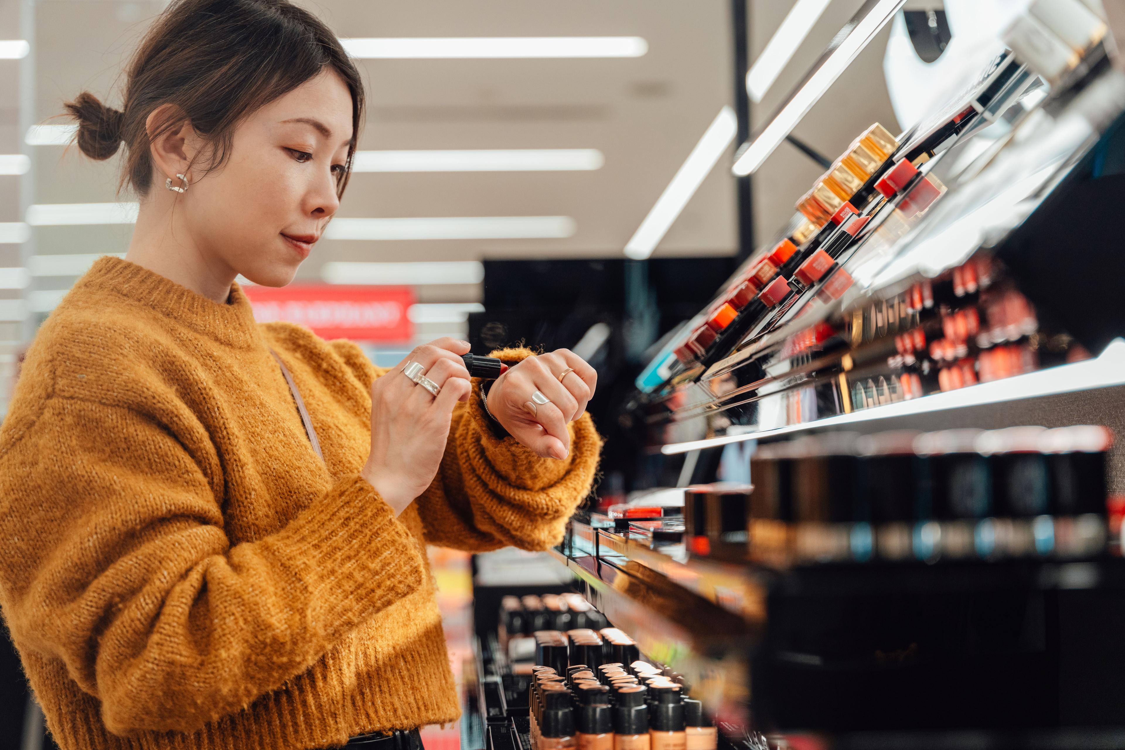 Woman trying makeup on her wrist in a cosmetics store.